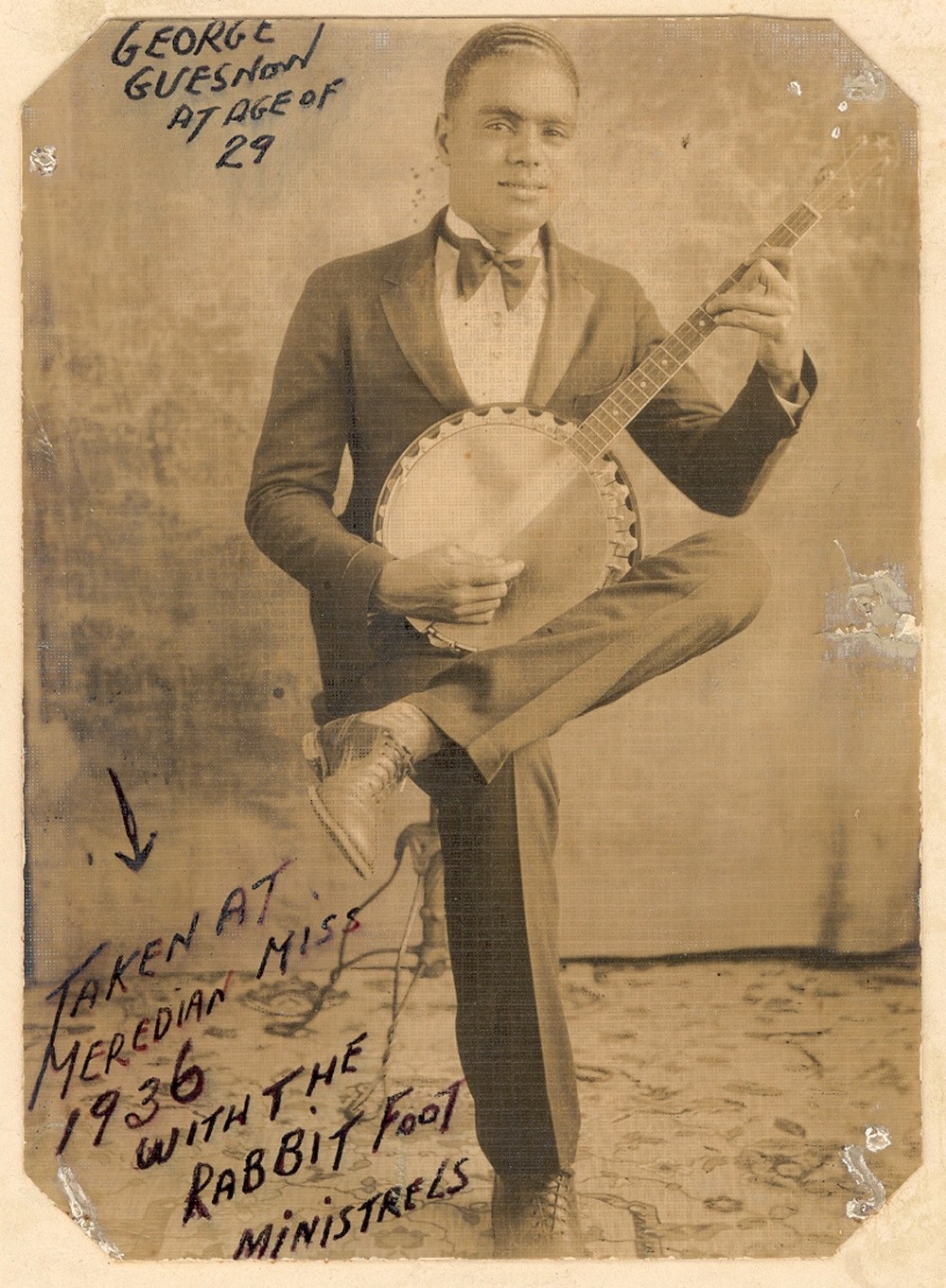 Vintage photo of Creole George Guesnon holding a banjo, taken in 1936 with the Rabbit Foot Minstrels in Meridian, Mississippi Creole George Guesnon, aged 29, photographed in 1936 while performing with the legendary Rabbit Foot Minstrels. A banjoist, guitarist, and songwriter, Guesnon left an indelible mark on American roots music.