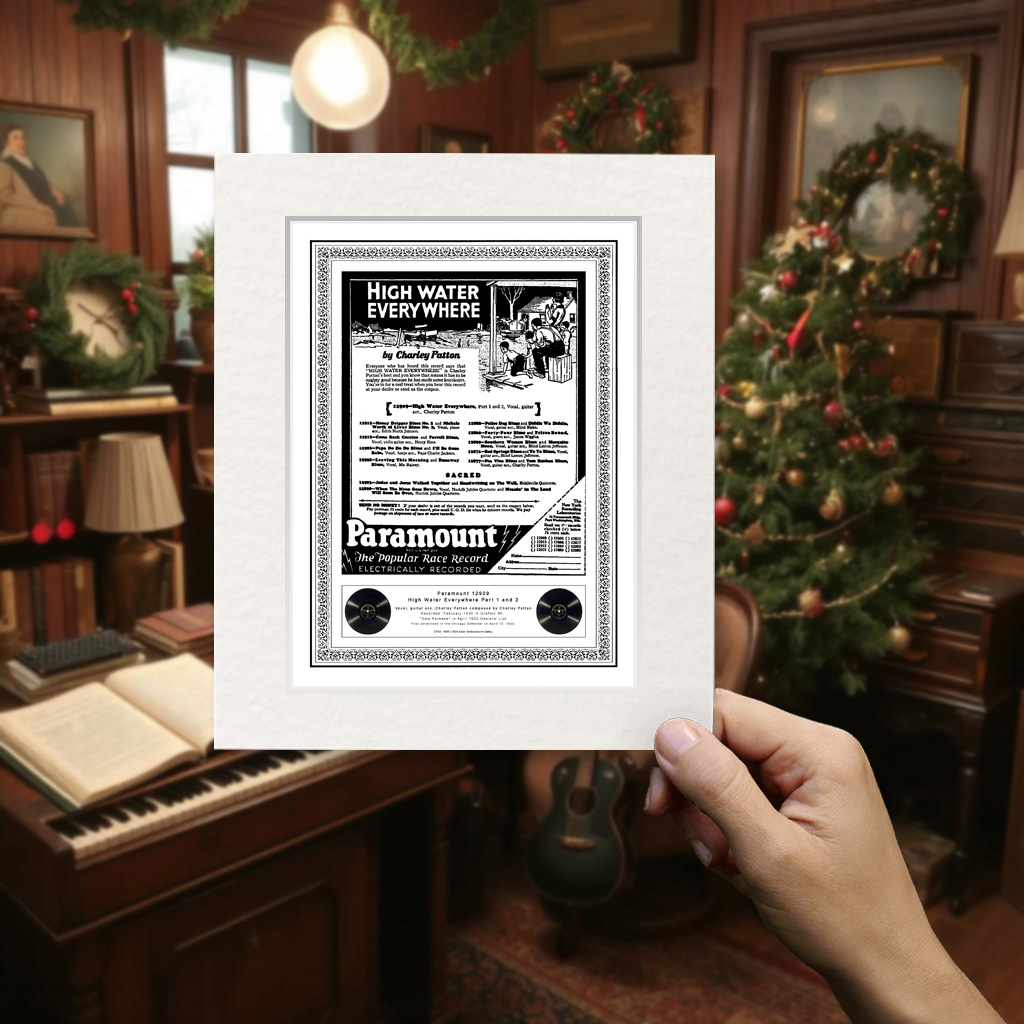 Charley Patton "High Water Everywhere" mounted print held by hand, with a Christmas tree and festive decor in the background.