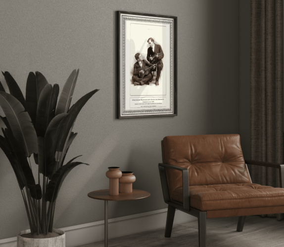 A framed print of Affectionate Musicians c.1910 - Art Print and Poster elegantly displayed on a dark grey wall beside a vintage-inspired leather armchair. The monochrome aesthetic and subtle lighting enhance the classic charm of the artwork.