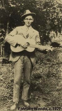 Photograph of Ephraim Woodie holding a guitar, likely taken in the late 1930s in rural North Carolina